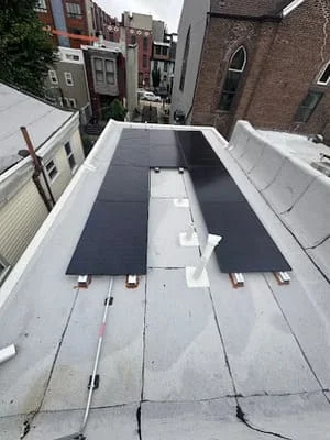 Dark membrane flat roof with white trim and mechanical fasteners installed on commercial building