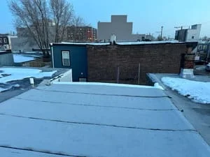 Commercial flat roof with light-colored membrane installation on large building