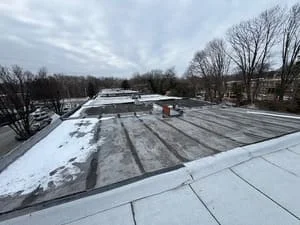 White membrane flat roof with drainage channels and HVAC equipment installation