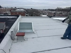 White membrane flat roof with roof penetrations and HVAC equipment on commercial building