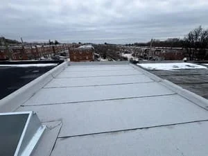 White membrane flat roof installation with seams on commercial building