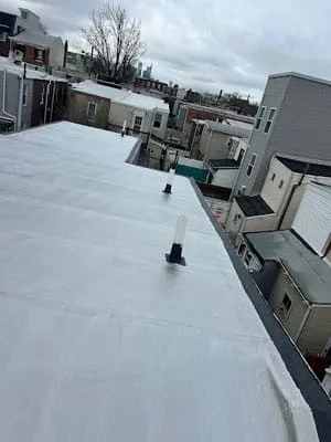 White membrane flat roof installation on commercial building with roof penetrations and HVAC units